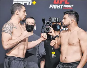  ?? Chris Unger Zuffa LLC ?? Robert Whittaker of Australia, left, and Kelvin Gastelum face off during the UFC weigh-in Friday in
Las Vegas. The winner likely will get the next shot at champion Israel Adesanya, who already has defeated both of them.