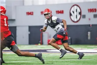  ?? GEORGIA PHOTO BY TONY WALSH ?? Georgia junior defensive back Lewis Cine chases receiver George Pickens during Tuesday’s first spring practice in Athens. Cine does not view the defenders as underdogs despite all the familiar faces returning on the Bulldogs offense.