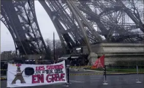  ?? Michel Euler/Associated Press ?? A union banner reads "Eiffel Tower employees on strike" outside the landmark on Monday in Paris. Visits to the monument were disrupted because of a strike over poor financial management.