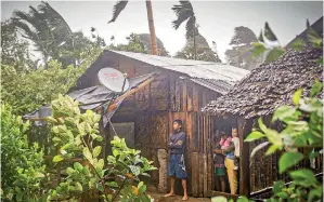  ?? AFP ?? Residents take shelter by their house as they observe rain and wind in Can-avid town, central Philippine­s, as Typhoon Vongfong makes landfall on Thursday. —