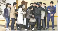  ?? LEE JIN-MAN, AP ?? A South Korean woman, center, is escorted by a security guard Tuesday upon her arrival from North Korea’s Kaesong industrial complex.