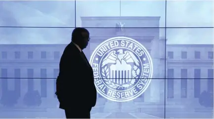  ??  ?? A MAN walks in front of an image of the Federal Reserve following the central bank’s two-day policy meeting in Washington last March.