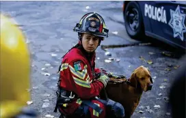  ??  ?? A rescue dog and his handler get ready to work at the site of building in Mexico City’s Roma Norte neighborho­od Friday. Rescue workers entered their fourth day of searching after Tuesday’s major earthquake devastated Mexico City and nearby states.