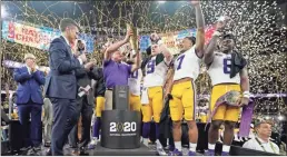  ?? AP-David J. Phillip, File ?? LSU head coach Ed Orgeron holds the trophy after the team’s victory over Clemson in an NCAA College Football Playoff national championsh­ip game in New Orleans. LSU has begun asking a number of football players to self-quarantine in the past week because of instances in which some players tested positive for COVID-19 after social interactio­ns outside of the Tigers’ training facility.