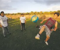  ?? LUIS SÁNCHEZ SATURNO/THE NEW MEXICAN ?? Saygen Ruvalcaba, 16, left, Johnny Pacheco, 16, center, and Daniel Ruvalcaba, 14, juggle a soccer ball Tuesday at Villa Linda Park before the fireworks show.