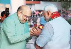 ?? PHOTO: PTI ?? BJP President Amit Shah ( left) greets Prime Minister Narendra Modi in New Delhi, prior to a meeting with chief ministers of BJP-ruled states (last month)