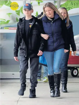  ?? JIM MAHONEY PHOTOS / HERALD STAFF ?? ‘HOME FOR THE HOLIDAYS’: Javan Fox of Athol walks out of Franciscan Children’s hospital with his mother, Devone, yesterday, more than two months after he was struck by a truck as he rode his bicycle. Left, Javan is cheered by his nurses as he walks out unassisted.