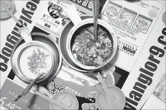  ??  ?? Frog porridge is a popular late-night meal in Singapore. Frog legs are served in a savory-sweet soy sauce and accompanie­d by a bowl of dense congee to cut the intense, punchy flavor.