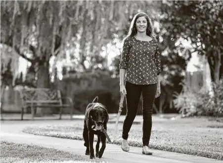  ?? Melissa Phillip / Staff photograph­er ?? ElizabethW­althall walks her dog Maggie on Monday in Houston. A high school teacher, Walthall says the election is personal for many of her students, especially those who are immigrants. They know their futures can change depending on who wins.