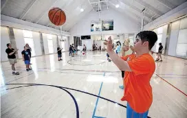  ?? [PHOTOS BY STEVE GOOCH, THE OKLAHOMAN] ?? George Cerbu practices his passing skills during the Down Syndrome Associatio­n of Central Oklahoma’s basketball camp.