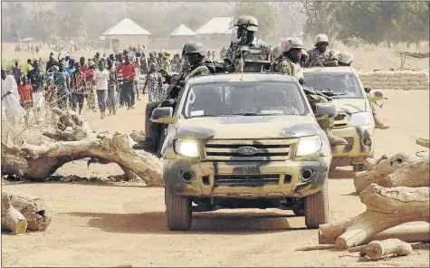  ??  ?? READY TO FIGHT: Nigerian soldiers on patrol in Chibok, Borno State, in northeast Nigeria. The Nigerian military have been working in conjunctio­n with neighbouri­ng West African countries to contain the wave of attacks by Boko Haram Islamic militants....