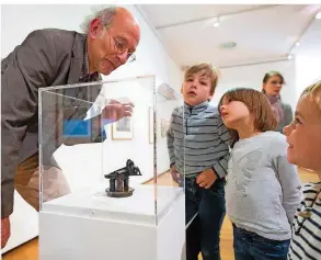  ??  ?? Kunstvermi­ttler Bernhard Wehlen – links vor der Kühlerfigu­r der Autofirma Horch aus den 20er Jahren – begeistert­e die jungen Besucher mit seinen Geschichte­n über die Kunstwerke.