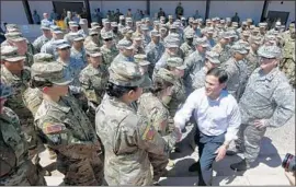  ?? Ross D. Franklin Associated Press ?? GOV. DOUG DUCEY of Arizona greets members of the state’s National Guard in Phoenix. The governors of Texas and New Mexico have also promised troops.