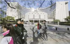  ?? — Reuters ?? People walk past the headquarte­rs of the People’s Bank of China in Beijing.