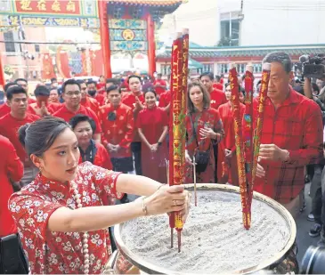  ?? ?? PRAYING FOR SUCCESS: Paetongtar­n ‘Ung Ing’ Shinawatra and Srettha Thavisin, right, lead members of the Pheu Thai Party, in Yaowarat yesterday to celebrate the Lunar New Year.