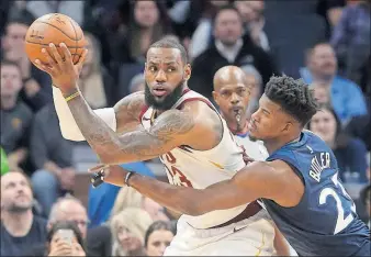  ?? [JIM MONE/THE ASSOCIATED PRESS] ?? LeBron James of the Cavaliers looks for help as Andrew Wiggins of the Timberwolv­es defends in the first half. ROCKETS 116, BULLS 107: PELICANS 112, PISTONS 109: