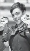  ?? AP/MTI/ZOLTAN MATHE ?? Thomas Daley of Great Britain shows off his gold medal won in the men’s diving 10-meter platform final and with his silver medal won in the mixed 3-meter synchro springboar­d final on Saturday during the 17th FINA Swimming World Championsh­ips in Duna...