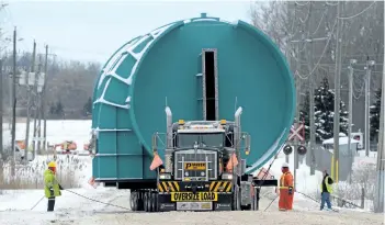  ?? DAVE JOHNSON/WELLAND TRIBUNE ?? One section of a nearly 31-metre-tall scrubber tower moves up Elm Street from Thurston Machine’s Invertose Drive plant Saturday in Port Colborne. The move to the Welland Canal, carried out by Welland’s Pioneer Heavy Haul Inc., took nearly four hours to...