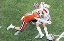  ?? BUTCH DILL/ AP ?? Ohio State quarterbac­k Justin Fields gets hit by Clemson linebacker James Skalski during the first half of the Sugar Bowl on Jan. 1 in New Orleans. Skalski was ejected from the game for targeting.