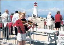  ?? JIM FOX/SPECIAL TO POSTMEDIA NEWS A young fiddler entertains the cruise ship crowds at Peggy’s Cove, N.S. ??