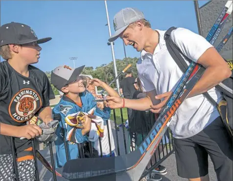  ?? Steph Chambers/Post-Gazette photos ?? Jake Guentzel signs autographs for fans after his “Da Beauty League” game this month at Braemar Arena in Edina, Minn.