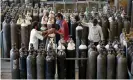  ?? Photograph: Amit Dave/Reuters ?? People carry oxygen cylinders after refilling them in a factory in Ahmedabad. India recorded 352,000 Covid cases on Monday.