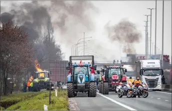  ?? — AFP photo ?? Dutch police officers with motorbikes operate as Dutch and Belgian farmers take part in a demonstrat­ion with tractors to block the border crossing between the Netherland­s and Belgium, in Hazeldonk.