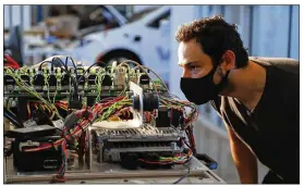  ?? JIM WILSON/NEW YORK TIMES ?? Alan Mond, an engineer at self-driving car company Voyage, checks a “hardware in the loop” (HIL) system in Palo Alto, California, recently. Voyage arranged for engineers to log on to their home computers for access to the HIL to run tests remotely.