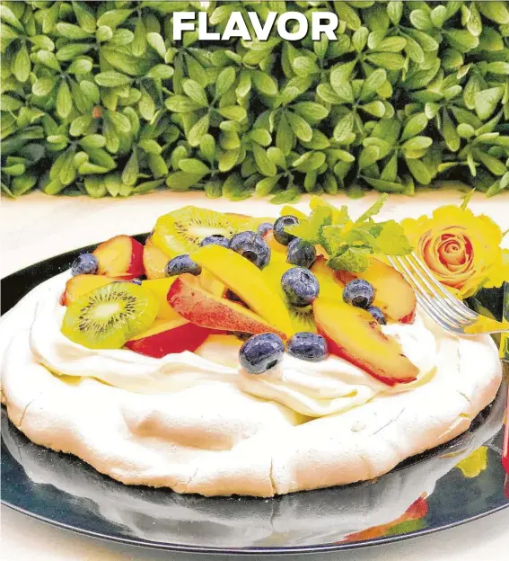  ?? Greg Morago / Staff ?? A pavlova — a baked meringue cake — is topped with whipped cream and sliced peaches, mango, kiwi and blueberrie­s. Recipes, page D2