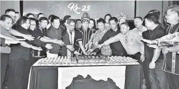  ??  ?? Tangau (middle) and Upko leaders cutting the anniversar­y cake.