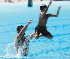  ?? Genaro Molina Los Angeles Times ?? GAGE DAVIS, 8, has some f light time with help from his dad, Anderson Davis, at the Hansen Dam Aquatic Center in Sylmar as the pair try to cool off.