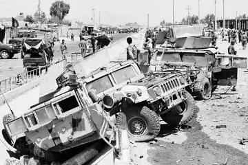  ??  ?? Afghan National Army (ANA) soldiers inspecting damaged army vehicles after a suicide attack in Lashkar Gah, Helmand province, Afghanista­n. — Reuters photo