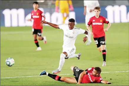  ??  ?? Real Madrid’s Vinicius Junior, (right), fights for the ball with Mallorca’s Aleksandar Sedlar during the Spanish La Liga soccer match between Real Madrid
and Mallorca at Alfredo di Stefano Stadium in Madrid, Spain, June 24. (AP)