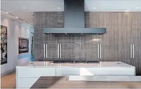  ?? PAUL STOPPI DUNAGAN DIVERIO VIA AP ?? A kitchen designed by Dunagan Diverio. The custom cladding appliance fronts and cabinetry create an integrated, serene sightline throughout an open plan kitchen.