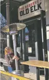  ?? MEAD GRUVER/ASSOCIATED PRESS ?? Whiskey tasting room manager Melinda Maddox moves a propane-fueled outdoor heater in downtown Fort Collins, Colo., in preparatio­n for opening earlier this month.