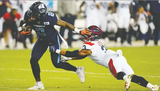  ?? JOHN E. SOKOLOWSKI/USA TODAY SPORTS ?? Toronto Argonauts receiver Ricky Collins Jr. breaks a tackle from Montreal Alouettes defensive back Patrick Levels Friday at Toronto's BMO Field.