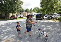  ??  ?? Etelvina Garcia walks with her grandchild­ren in the mobile home park where five people were killed. She had chatted occasional­ly with the suspect and had urged her to have faith in God in troubled times.