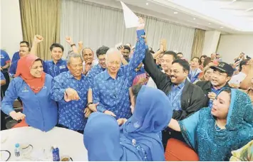  ??  ?? STILL IN POWER: Najib (centre) with the BN leaders celebrate after getting the mandate to form the government at Menara Dato Onn. — Bernama photo