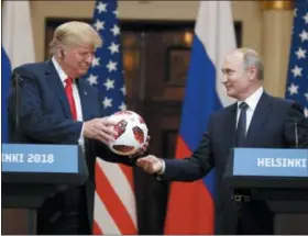  ?? ALEXANDER ZEMLIANICH­ENKO — THE ASSOCIATED PRESS ?? Russian President Vladimir Putin gives a soccer ball to U.S. President Donald Trump, left, during a press conference after their meeting at the Presidenti­al Palace in Helsinki, Finland, Monday.