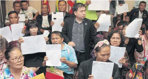  ?? TAWATCHAI KEMGUMNERD ?? Victims of pyramid fraud schemes assemble at the Department of Special Investigat­ion office in Lak Si district yesterday to petition DSI chief Paisit Wongmuang to order his subordinat­es to speed up a probe into eight companies that allegedly swindled...
