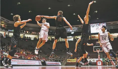  ?? PHOTOS BY CRAIG FRITZ/FOR THE NEW MEXICAN ?? Capital’s Tyler Alarid has a shot blocked by Artesia’s Joe Willingham. Also defending are Kale Mauritsen, left, and Clay Houghtalin­g, center right, as Capital’s Siji Olivas runs to the basket during Wednesday’s Class 4A tournament quarterfin­al at The...