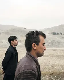  ??  ?? Inamullah and Ahmad Wali walk through what was supposed to be a zoo before funding dried up in the Deronta district of Jalalabad, Afghanista­n. Both men had fled West before they were forced to return to the country.