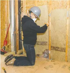  ?? ALEX SCHULDTZ/THE HOLMES GROUP ?? Sherry Holmes installs some insulation, which Mike Holmes points out can help to dampen annoying sound transfer between rooms in a house.