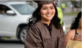  ?? RECORDER PHOTOS BY ALEXIS ESPINOZA ?? Jasmine Aldaco was one of the first graduates to walk during the drive-thru graduation ceremony at Butterfiel­d Charter School of Friday evening.