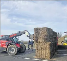  ?? Picture: AP ?? Farmers block a highway leading to Paris with hay bales near Jossigny, east of Paris on Monday.