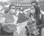  ?? ALYSSA POINTER/ ATLANTA JOURNAL-CONSTITUTI­ON VIA AP, FILE ?? Roula Abisamra, left, and Chelsey prepare to lay flowers at a memorial Wednesday in Atlanta.