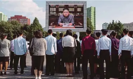  ?? [FOTO AFP] ?? Orang ramai menonton siaran berita memaparkan Jong-un memberi ucapan di Pyongyang, semalam.
