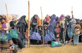  ?? AP African News Agency (ANA) ?? ROHINGYA Muslim women with their children stand in a queue outside a food distributi­on centre at Balukhali refugee camp. The rise of traffickin­g has left many women fearing victimisat­ion at camps. | MANISH SWARUP