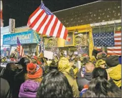  ?? ?? Protesters gather at Mac’s Public House on Staten Island as sheriff’s deputies enforce the closing of the bar for violating COVID restrictio­ns in December 2020.