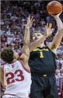  ?? ?? Michigan’s Hunter Dickinson, right, shoots while defended by Indiana’s Trayce Jackson-davis during Sunday’s overtime loss.